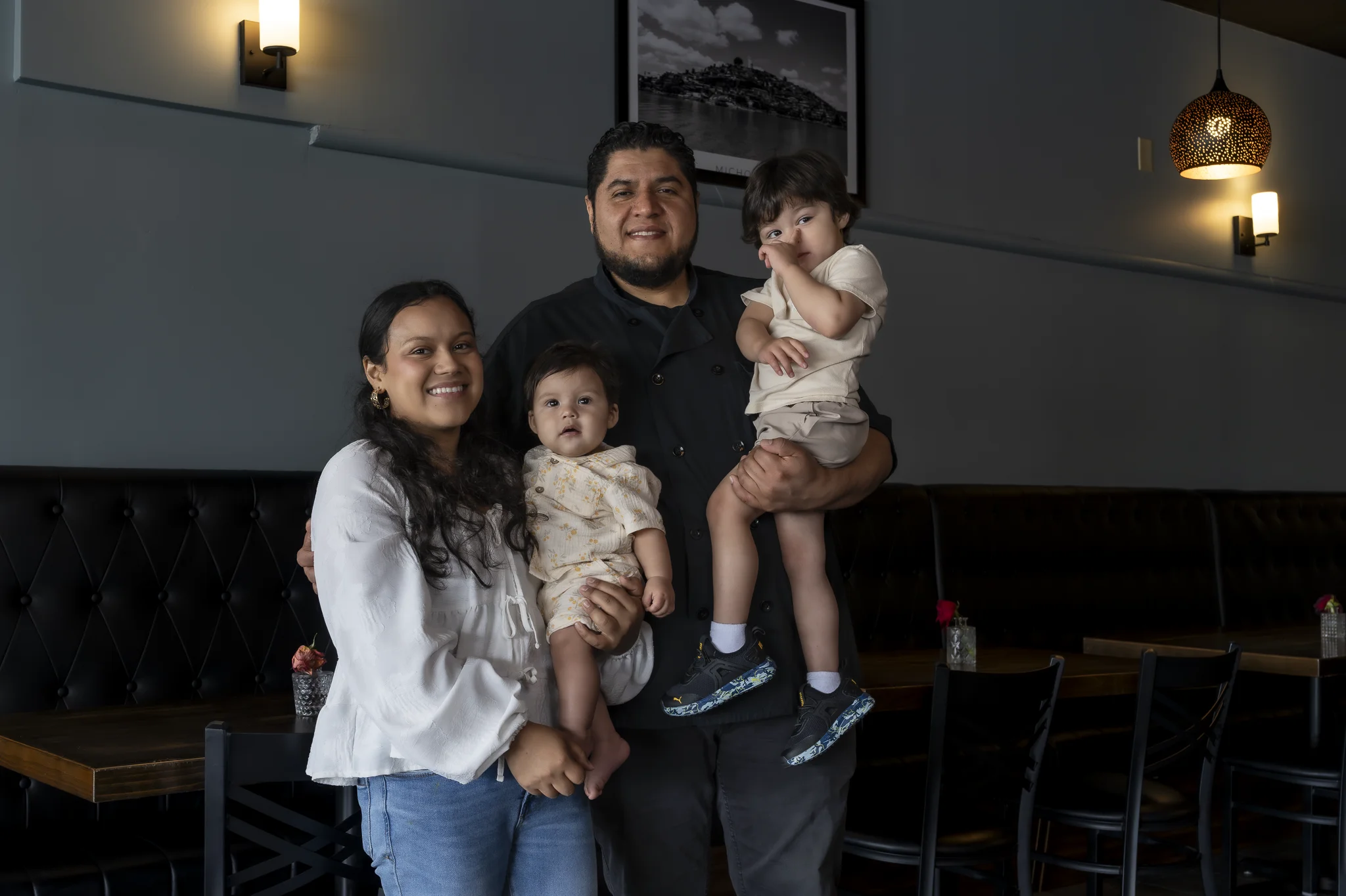 Chef Victor and his family smiling together in the El Fornino dining room